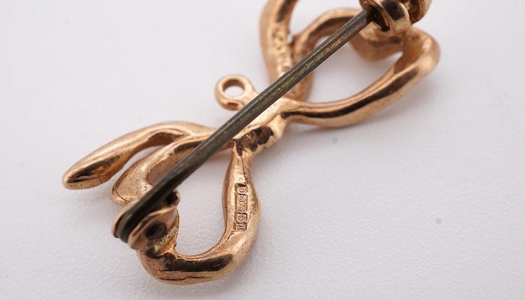 Five assorted items of jewellery including an early 20th century yellow metal and seed pearl set acorn bar brooch, 31mm, a similar yellow metal and split pearl ring ring (one missing), with diamond chip spacers, a modern